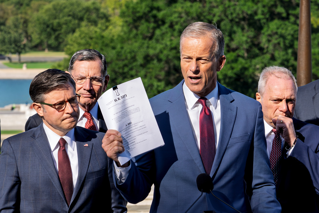 Speaker of the House Mike Johnson, R-La., left, listens as Senate Majority Leader John Thune, R-S.D., holds a copy of the continuing appropriations bill as top Republicans in Congress hold a news conference on the government shutdown, at the Capitol in Washington, Wednesday, Oct. 1, 2025. (AP Photo/J. Scott Applewhite)