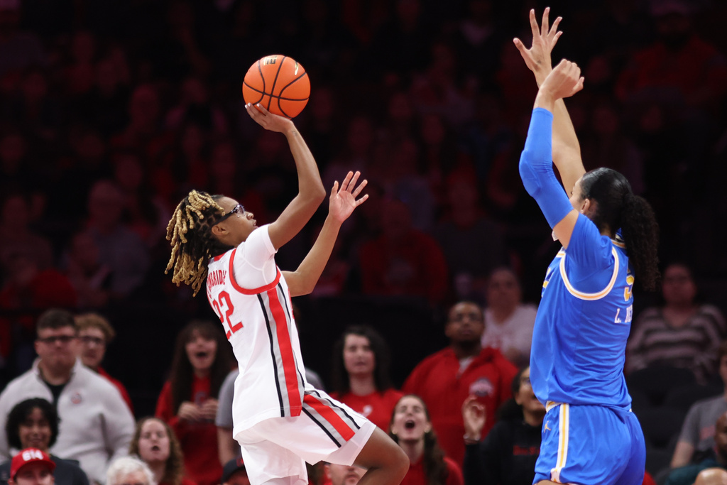 Ohio State guard Jaloni Cambridge, left, looks to shoot against UCLA center Lauren Betts, right, during the first half of an NCAA college basketball game in Columbus, Ohio, Sunday, Dec. 28, 2025. (AP Photo/Paul Vernon)