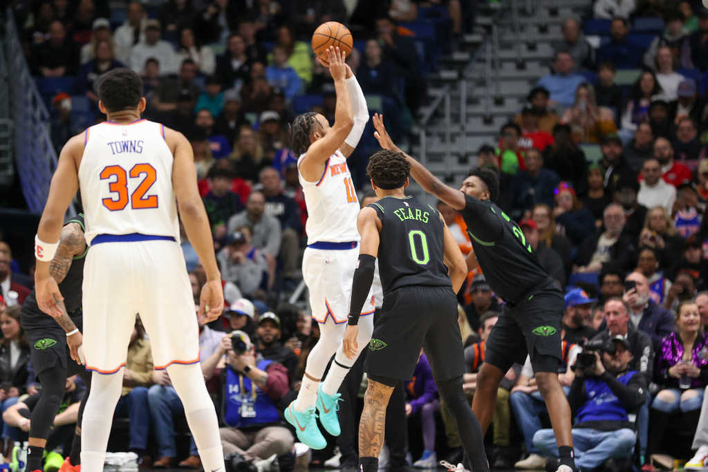 New York Knicks guard Jalen Brunson (11) shoots a jumper over New Orleans Pelicans center Derik Queen, right, in the first half of an NBA basketball game in New Orleans, Monday, Dec. 29, 2025. (AP Photo/Peter Forest)