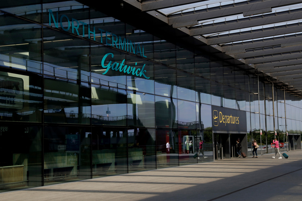 FILE - Passengers walk into the Departures entrance at the North Terminal of Gatwick Airport near Crawley, just south of London, on July 22, 2020. (AP Photo/Matt Dunham, File)
