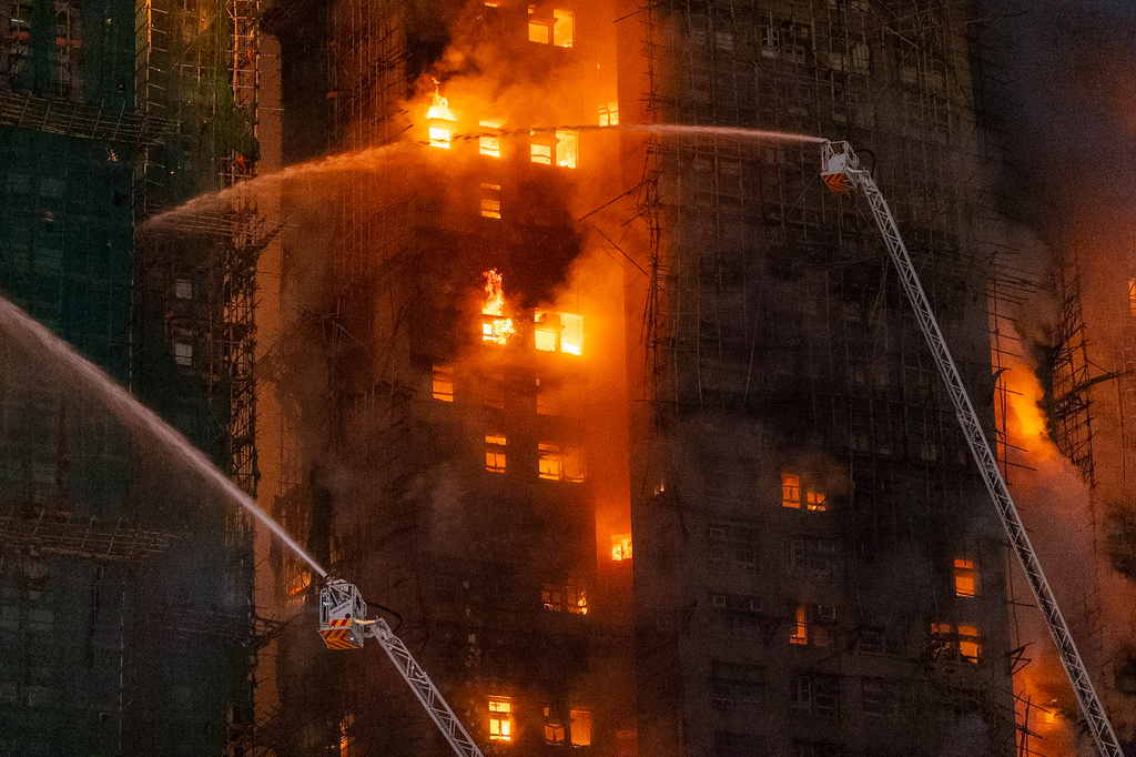 Firefighters try to extinguish a flames engulfing a building after a fire broke out at Wang Fuk Court, a residential estate in the Tai Po district of Hong Kong's New Territories, Wednesday, Nov. 26 2025. (AP Photo/Chan Long Hei)