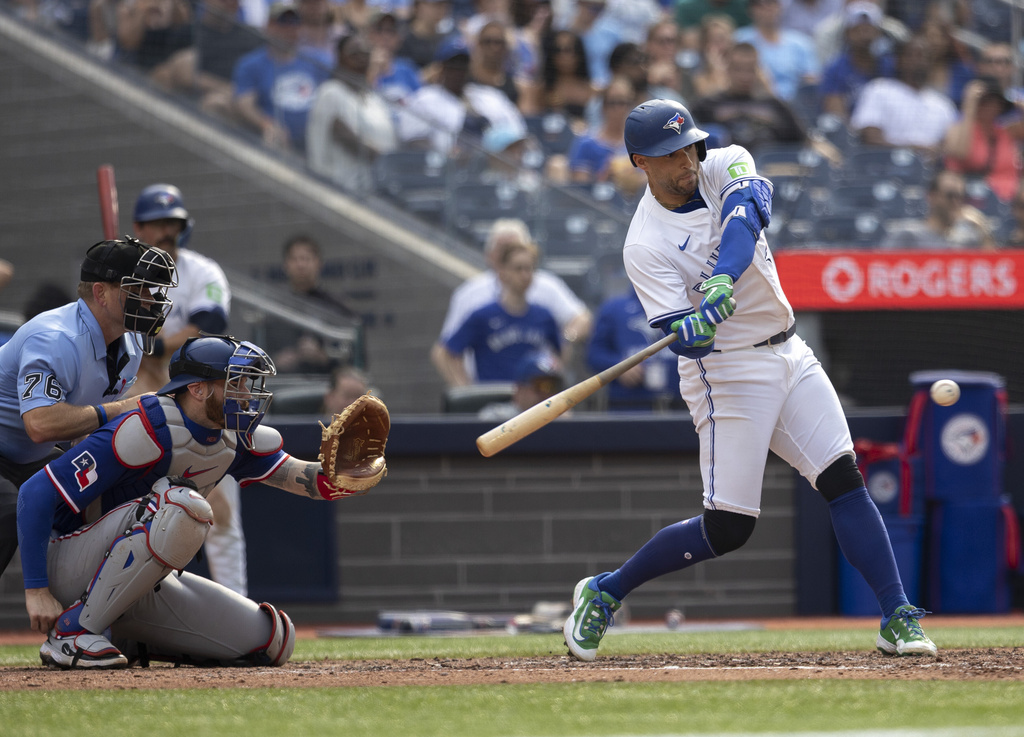 Toronto Blue Jays' George Springer hits a single against the Texas Rangers during the fifth inning of a baseball game in Toronto, Saturday, Aug. 16, 2025. (Tara Walton/The Canadian Press via AP)