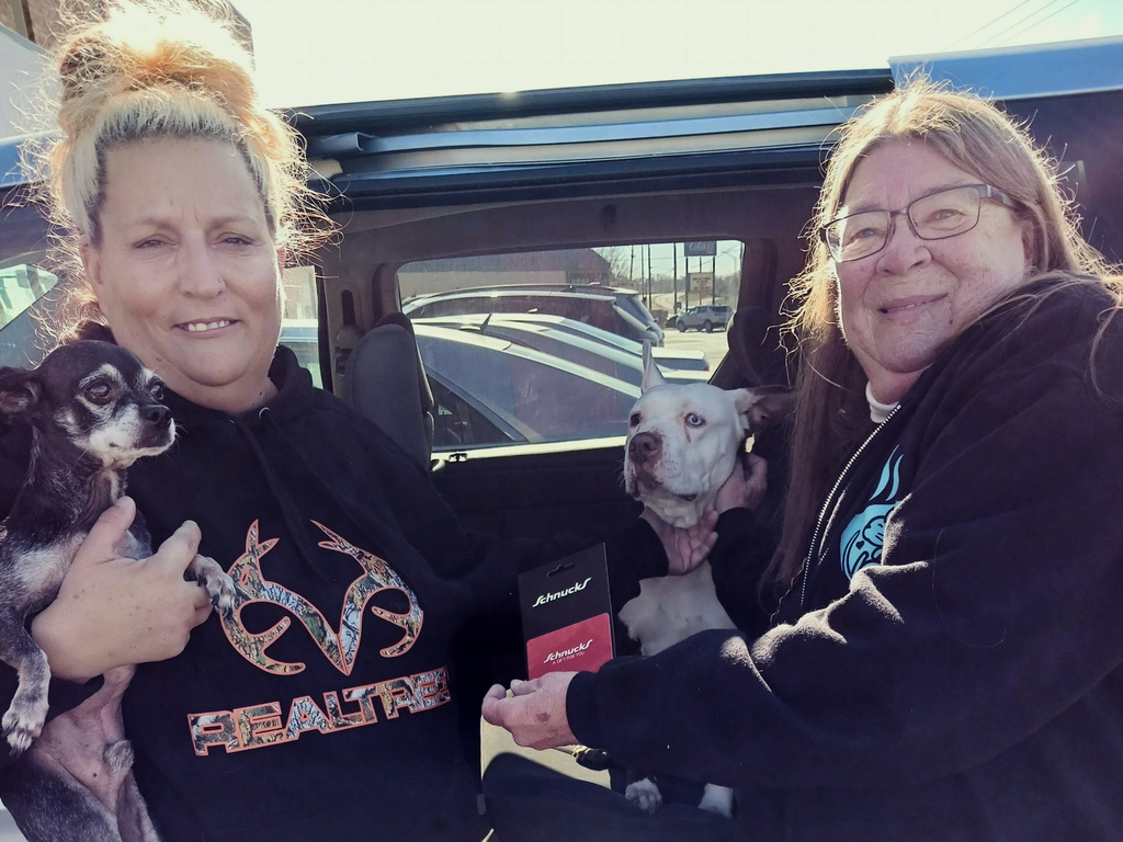 Teresa Paris, right, gives SNAP recipient Sarah Lungwitz a grocery store gift card on Oct. 30, 2025, in Loves Park, Illinois, as part of a nonprofit's efforts to help struggling pet owners feed themselves and their animals amid disruptions in the food aid benefit. (Gene Paris via AP)