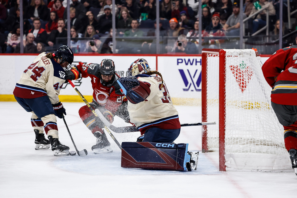 Montreal Victoire goaltender Ann-Renee Desbiens (35) saves the shot from Ottawa Charge's Emily Clark (26) as Amanda Boulier (44) defends during second period PWHL action in Winnipeg, Manitoba, Sunday, March 22, 2026. (John Woods/The Canadian Press via AP)
