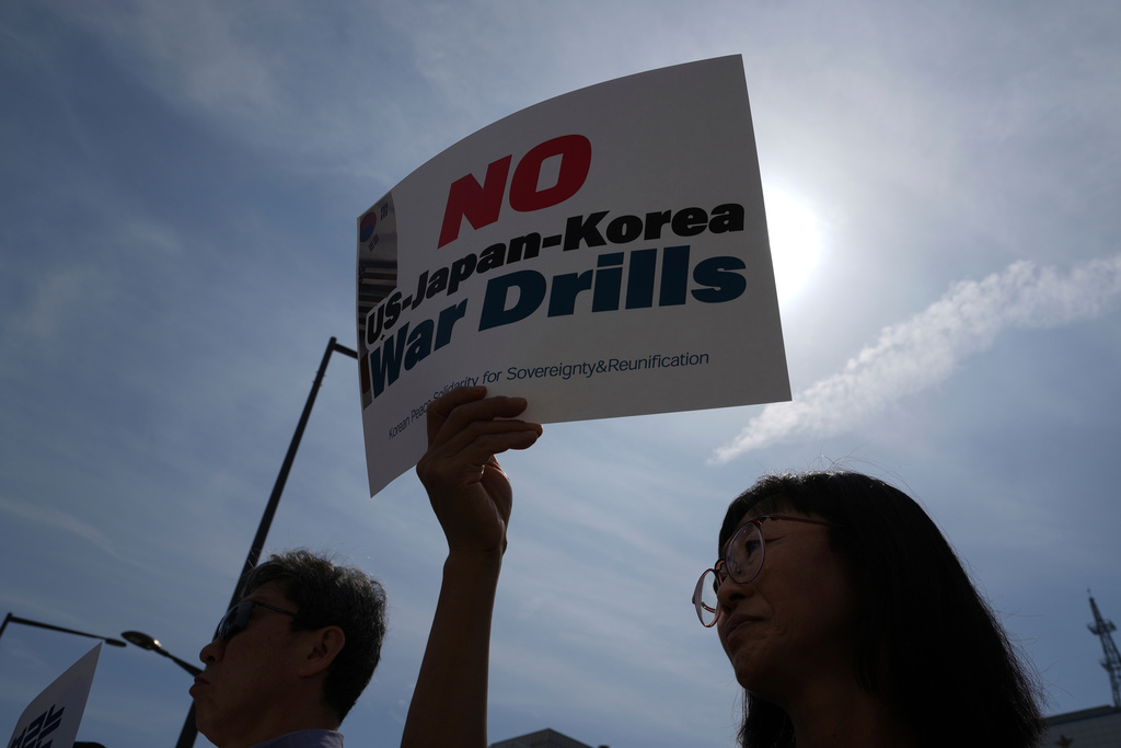 A protester holds a sign during a press conference to oppose the military exercise called Freedom Edge in Seoul, South Korea, Monday, Sept. 15, 2025. (AP Photo/Lee Jin-man)