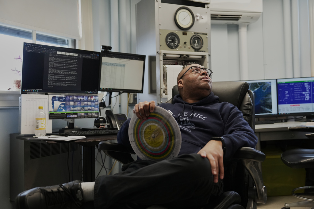 Matthew Douglas, the observatory's chief weather observer, holds a psychrometric calculator while in his office at the Blue Hill Observatory and Science Center, Friday, March 13, 2026, in Milton, Mass. (Laura Martin Agudelo/MIT Graduate Program in Science Writing via AP)