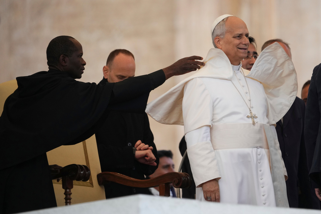 An aide adjusts Pope Leo XIV's mozzetta during his weekly general audience in St. Peter's Square at The Vatican, Wednesday, Dec.17, 2025. (AP Photo/Alessandra Tarantino)