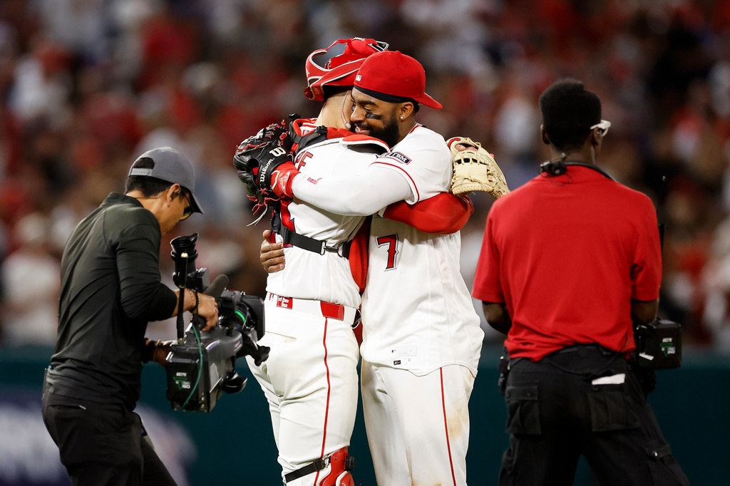 Los Angeles Angels catcher Logan O'Hoppe (14) and left fielder Jo Adell (7) embrace at the end of a baseball game against the Seattle Mariners, Saturday, April 4, 2026, in Anaheim, Calif. (AP Photo/Caroline Brehman)