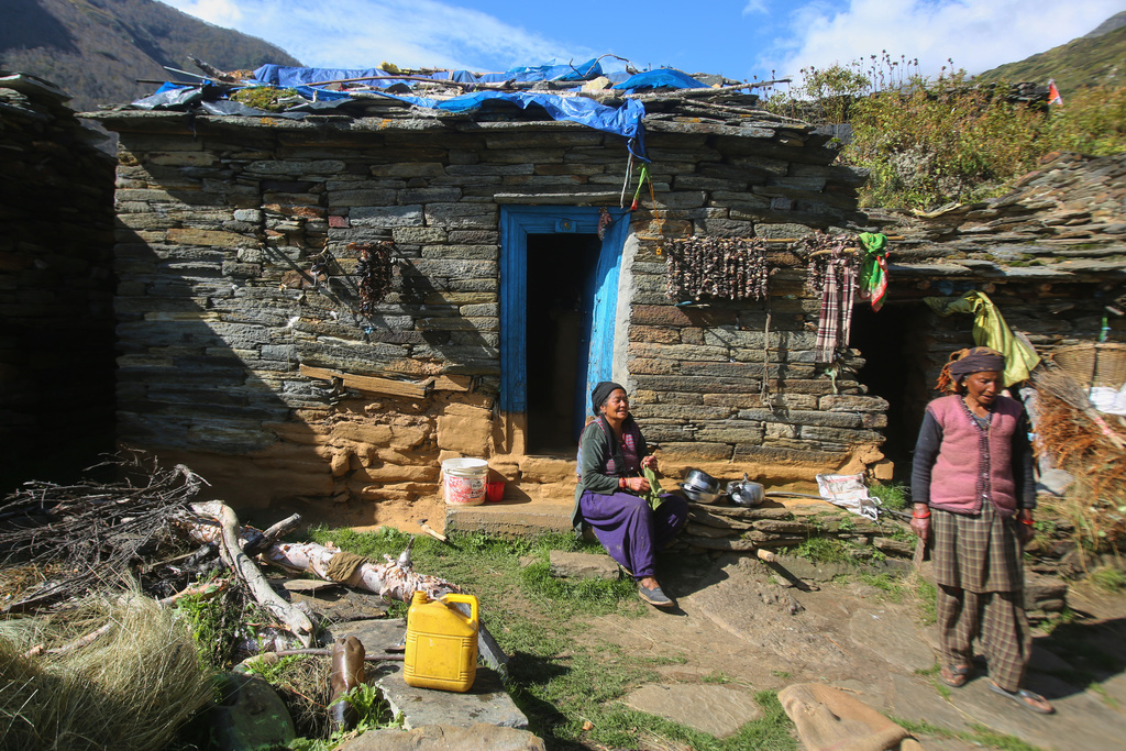 Nomi Devi, left, sits outside her house and chats with a neighbor in Laspa village, situated on the route of a trek to the Nanda Devi base camp in the northern Indian Himalayan state of Uttarakhand, on Sept. 28, 2025. (AP Photo/Satish Sharma)