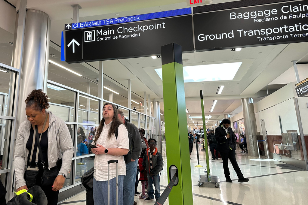 Passengers wait outside a Transportation Security Administration checkpoint at Hartsfield-Jackson Atlanta International Airport on Saturday, March, 21, 2026, (AP Photo/Jeff Amy)