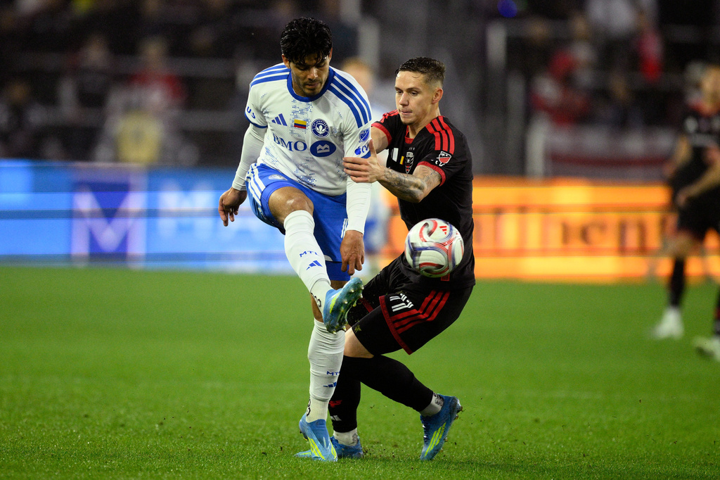 CF Montreal defender Brayan Vera, left, kicks the ball past D.C. United forward Louis Munteanu (11) during the first half of an MLS soccer match, Saturday, May 23, 2026, in Washington. (AP Photo/Nick Wass)