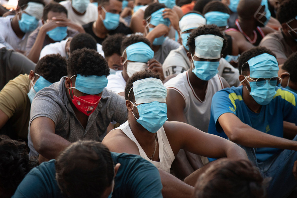 FILE - People from China, Vietnam and Ethiopia, believed to have been trafficked and forced to work in scam centers, sit with their faces masked while in detention after being released from the centers in Myawaddy district in eastern Myanmar, Feb. 26, 2025. (AP Photo/Thanaphon Wuttison, File)