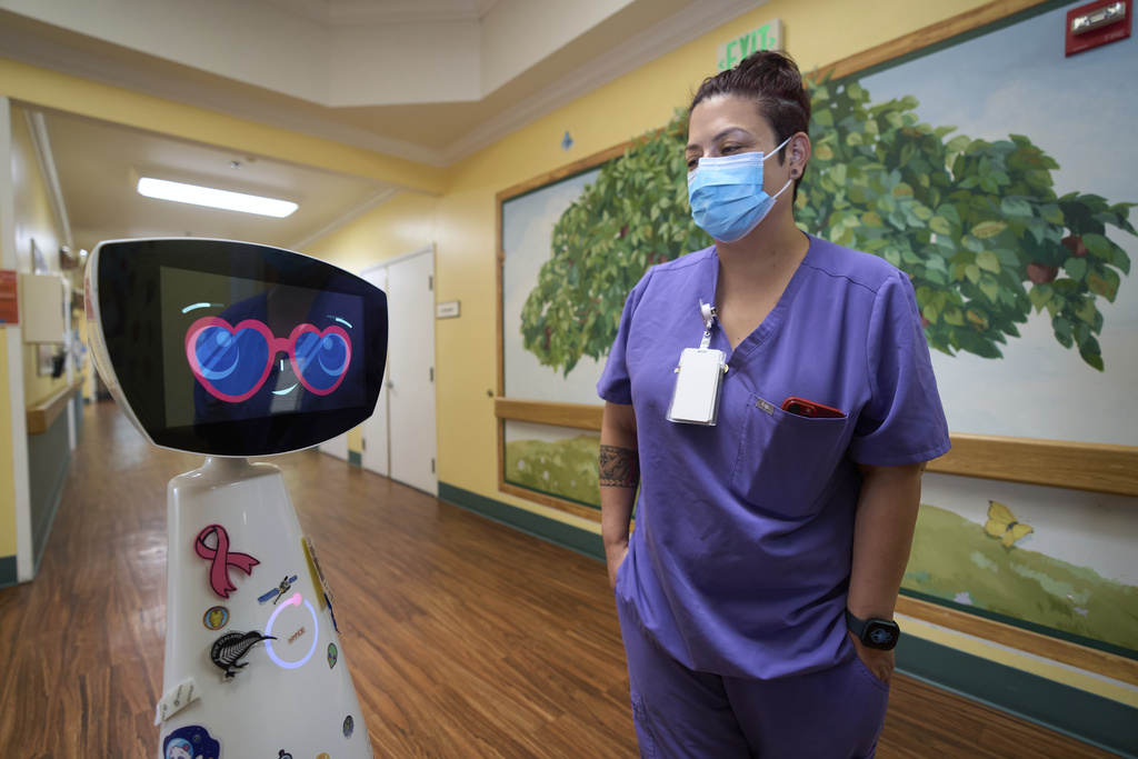 Activities Coordinator Melissa Delaney interacts with Robin the Robot as it visits patients' rooms at the HealthBridge Orange Specialty Pediatric Hospital in Orange, Calif., on Friday, Sept. 12, 2025. (AP Photo/Damian Dovarganes)
