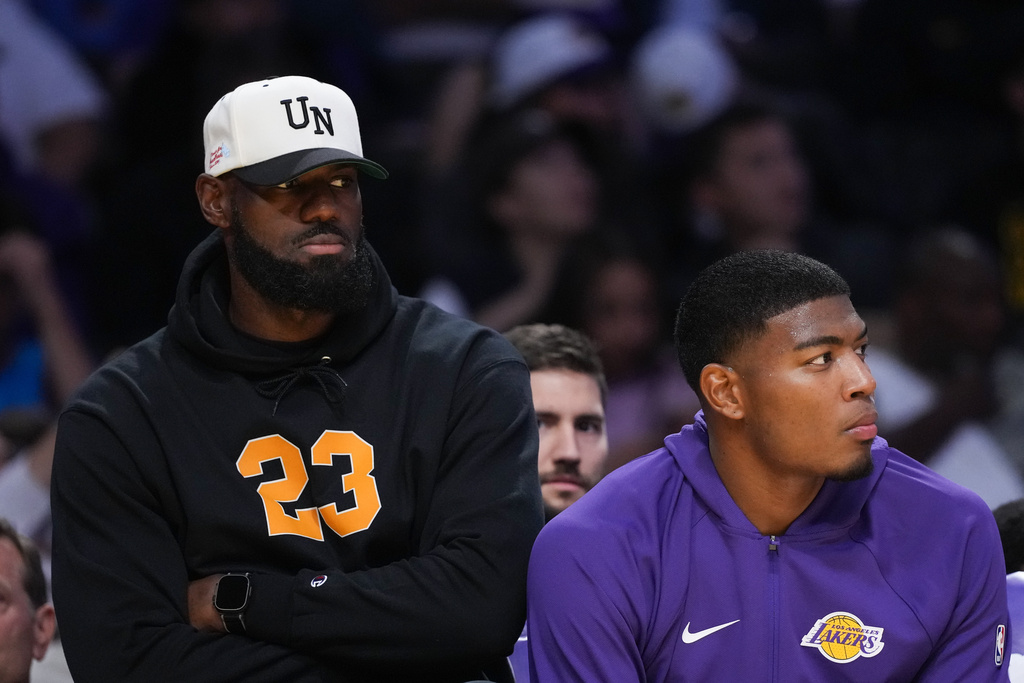 Los Angeles Lakers' Lebron James, left, and Rui Hachimura watch action from the bench during the first half of a preseason NBA basketball game against the Golden State Warriors Sunday, Oct. 12, 2025, in Los Angeles. (AP Photo/Jae C. Hong)