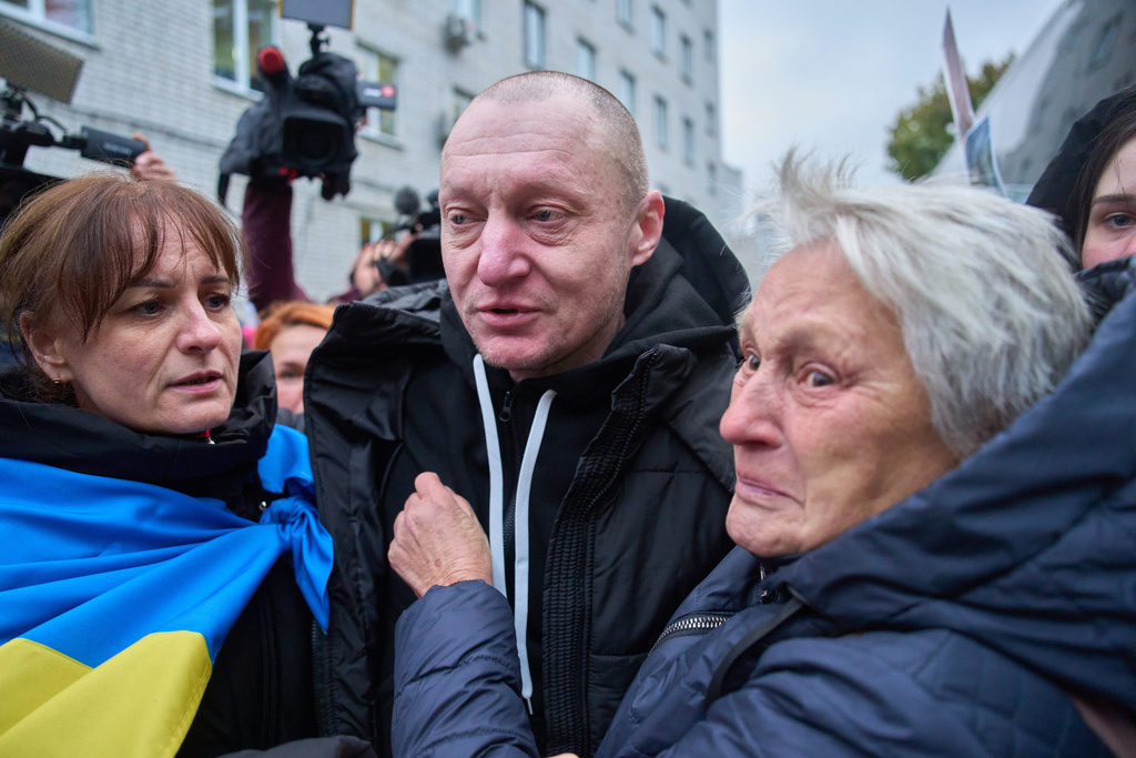 A mother holds her son soldier as he returns from Russian captivity during a POW exchange between Russia and Ukraine in Chernyhiv region, Ukraine, Thursday, Oct, 2025. (AP Photo/Efrem Lukatsky)