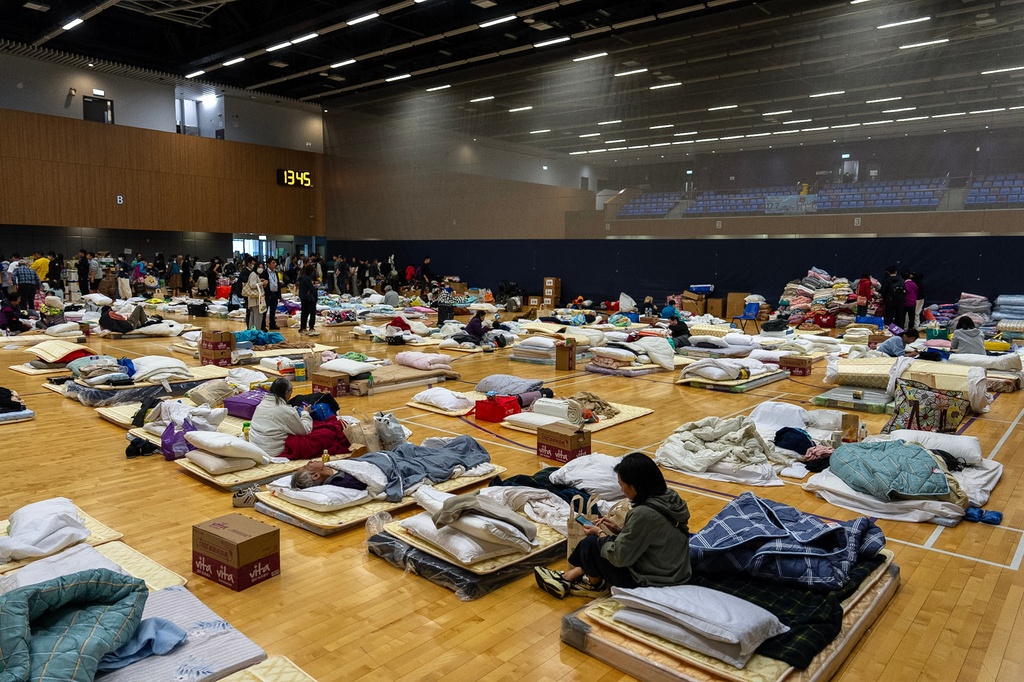 Residents rest at a temporary shelter near the fire scene at Wang Fuk Court, a residential estate in the Tai Po district of Hong Kong's New Territories, Thursday, Nov. 27, 2025. (AP Photo/Chan Long Hei)