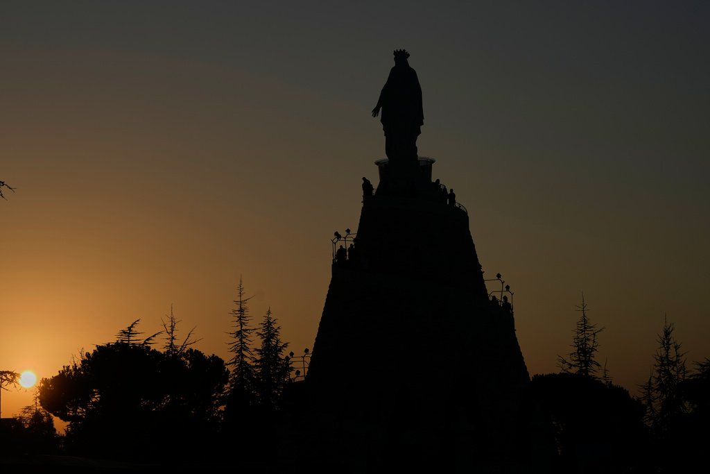 Worshippers visit Our Lady of Lebanon shrine in Harissa, north of Beirut, Lebanon, Sunday, Nov. 9, 2025, as the sun sets over the Mediterranean Sea. (AP Photo/Hassan Ammar)