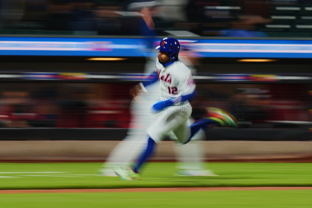 New York Mets' Francisco Lindor (12) runs toward home plate to score on a double by Francisco Alvarez during the fourth inning of a baseball game against the Minnesota Twins Wednesday, April 22, 2026, in New York. (AP Photo/Frank Franklin II)