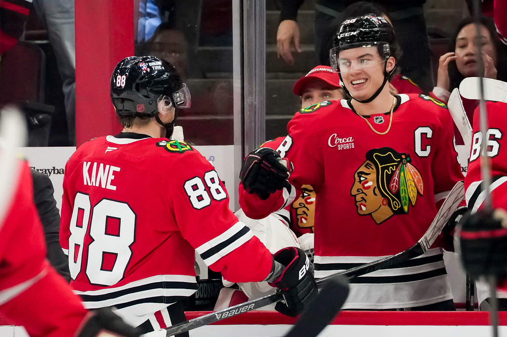 Chicago Blackhawks right wing Patrick Kane (88) celebrates a goal by Frank Nazar, not pictured, with Chicago Blackhawks center Connor Bedard (98) during the first period of an NHL hockey game against the Winnipeg Jets, Thursday, Oct. 15, 2026, in Chicago. (AP Photo/Harry Figiel)