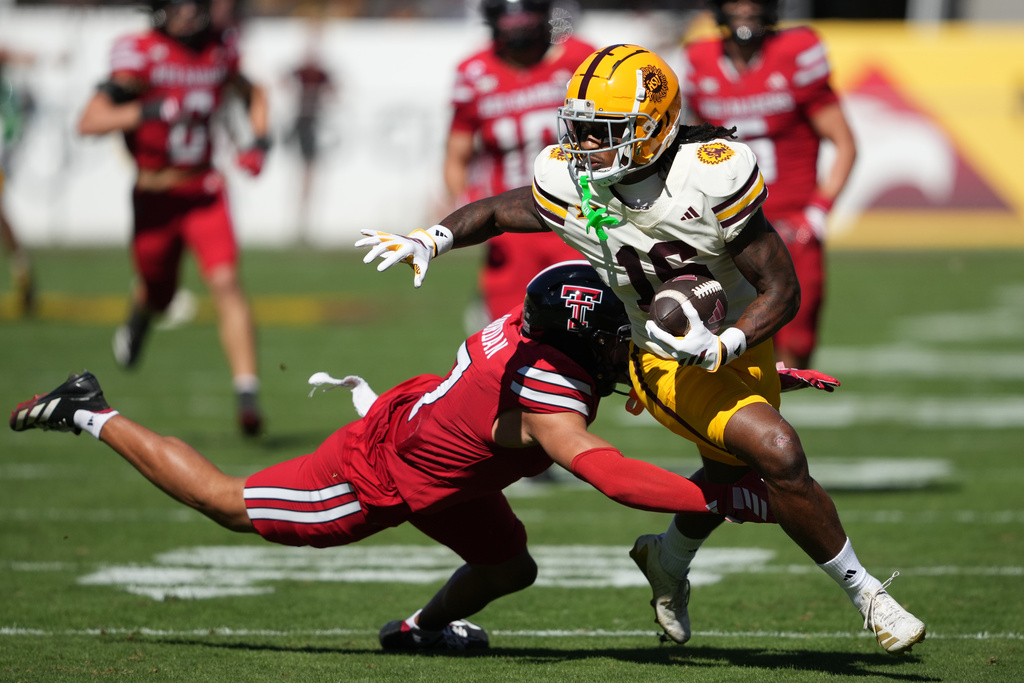 Arizona State wide receiver Jaren Hamilton, right, runs with the ball away from Texas Tech defensive back Brenden Jordan, left, in the first half of an NCAA college football game, Saturday, Oct. 18, 2025, in Tempe, Ariz. (AP Photo/Rick Scuteri)