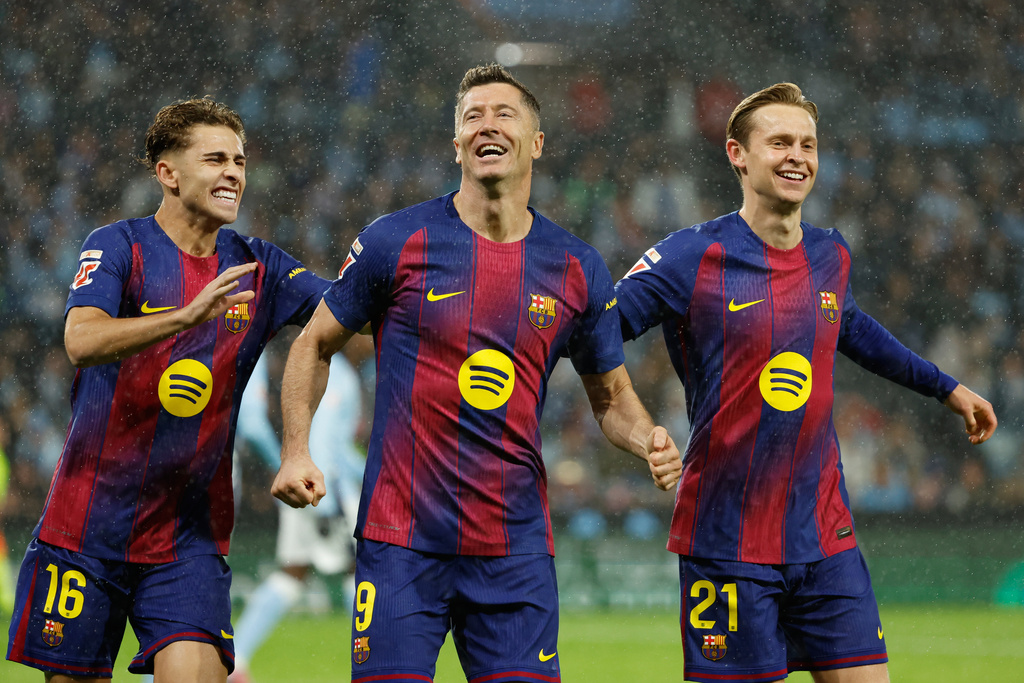 Barcelona's Robert Lewandowski, center, celebrates scoring his side's opening goal from the penalty spot during the Spanish La Liga soccer match between Celta Vigo and Barcelona in Vigo, Spain, Sunday, Nov. 9, 2025. (AP Photo/Lalo R. Villar)