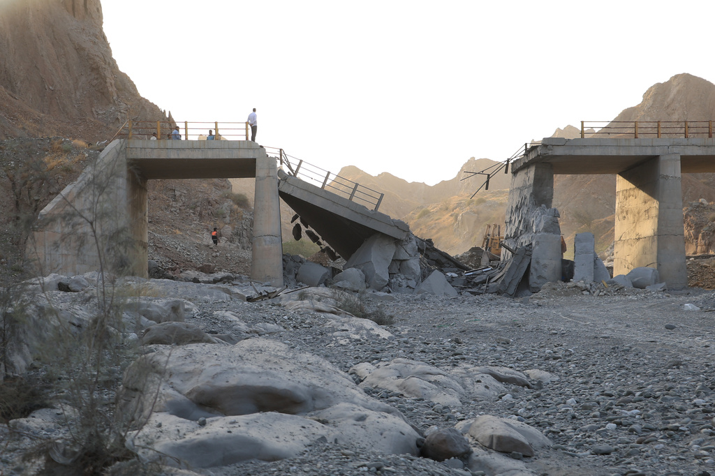 People stand on a bridge destroyed after a strike in Hormozgan province, southern Iran, Saturday, July 18, 2026. (Amirhosein Khorgooi/Iranian Students' News Agency via AP)