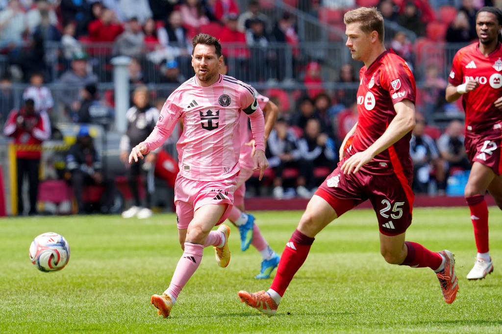 Inter Miami CF midfielder Lionel Messi (10) and Toronto FC defender Walker Zimmerman (25) chase the ball during first half MLS soccer in Toronto on Saturday, May 9, 2026. (Frank Gunn /The Canadian Press via AP)