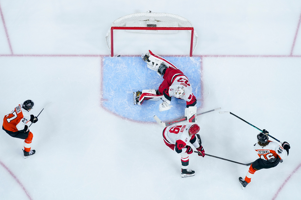 Philadelphia Flyers center Trevor Zegras, right, scores against Carolina Hurricanes goalie Brandon Bussi, center top, during the second period of an NHL hockey game, Monday, April 13, 2026, in Philadelphia. (AP Photo/Chris Szagola)