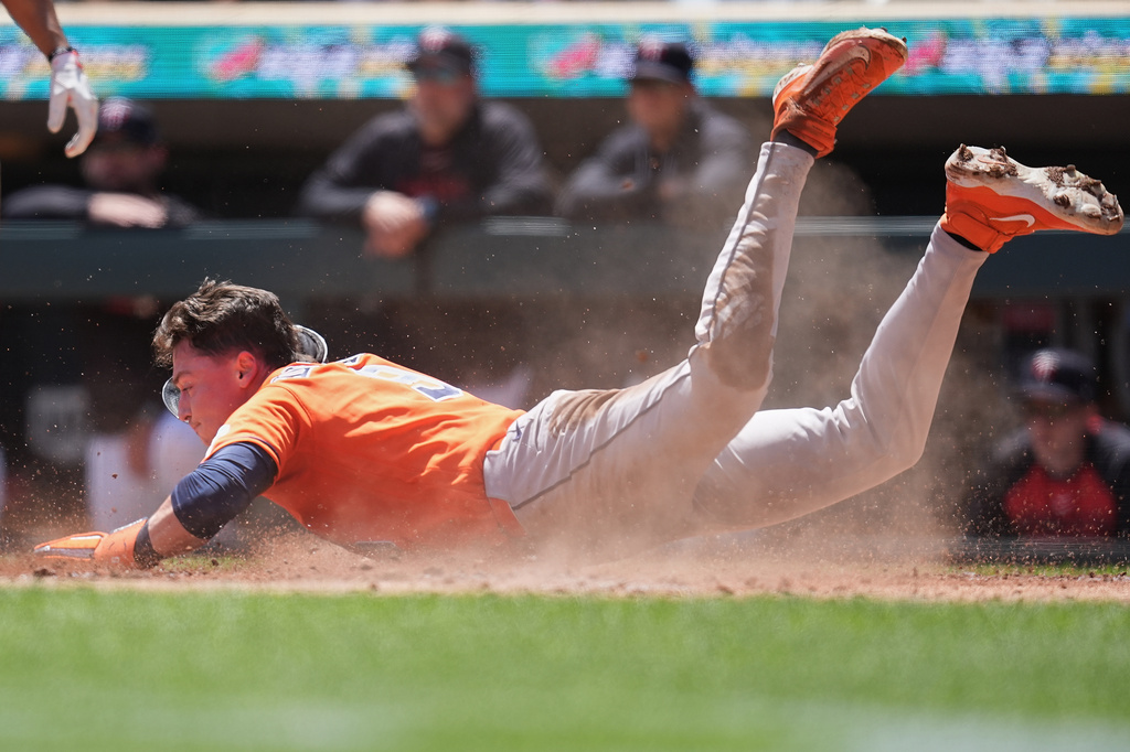 Houston Astros' Zach Dezenzo scores off an RBI-single hit by Christian Vázquez (2) during the second inning of a baseball game against the Minnesota Twins, Wednesday, May 20, 2026, in Minneapolis. (AP Photo/Abbie Parr)
