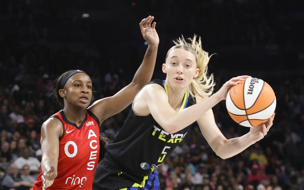 Dallas Wings guard Paige Bueckers (5) passes in front of Las Vegas Aces guard Jackie Young (0) during the first half of a WNBA basketball game, Sunday, Aug. 17, 2025, in Las Vegas. (Steve Marcus/Las Vegas Sun via AP)