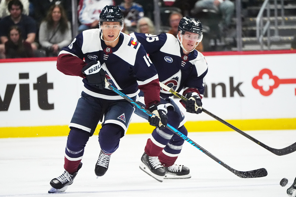 Colorado Avalanche center Jack Drury, front, collects the puck as left wing Victor Olofsson follows in the first period of an NHL hockey game against the Dallas Stars, Saturday, Oct. 11, 2025, in Denver. (AP Photo/David Zalubowski)