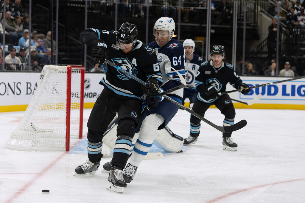 Utah Mammoth left wing Lawson Crouse, front, fights for the puck against Winnipeg Jets defenseman Logan Stanley (64) during the first period of an NHL hockey game, Sunday, Dec. 21, 2025, in Salt Lake City. (AP Photo/Melissa Majchrzak)