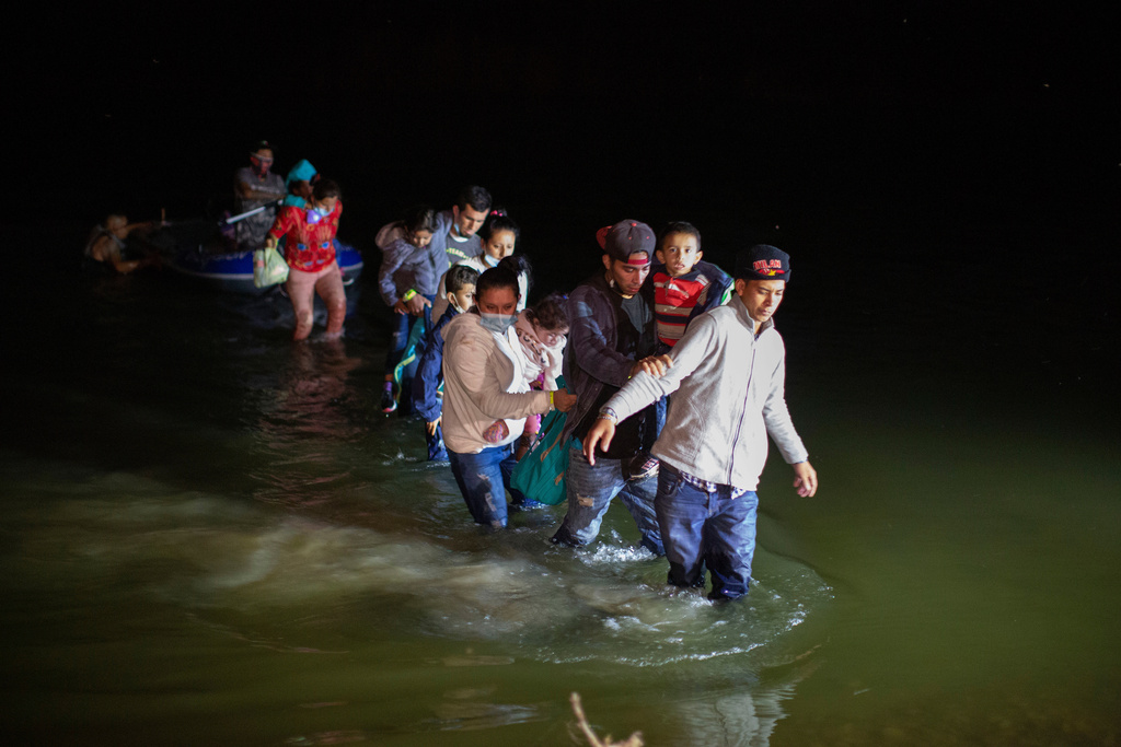 FILE - Migrant families wade through shallow waters toward Roma, Texas, March 24, 2021. (AP Photo/Dario Lopez-Mills, File)