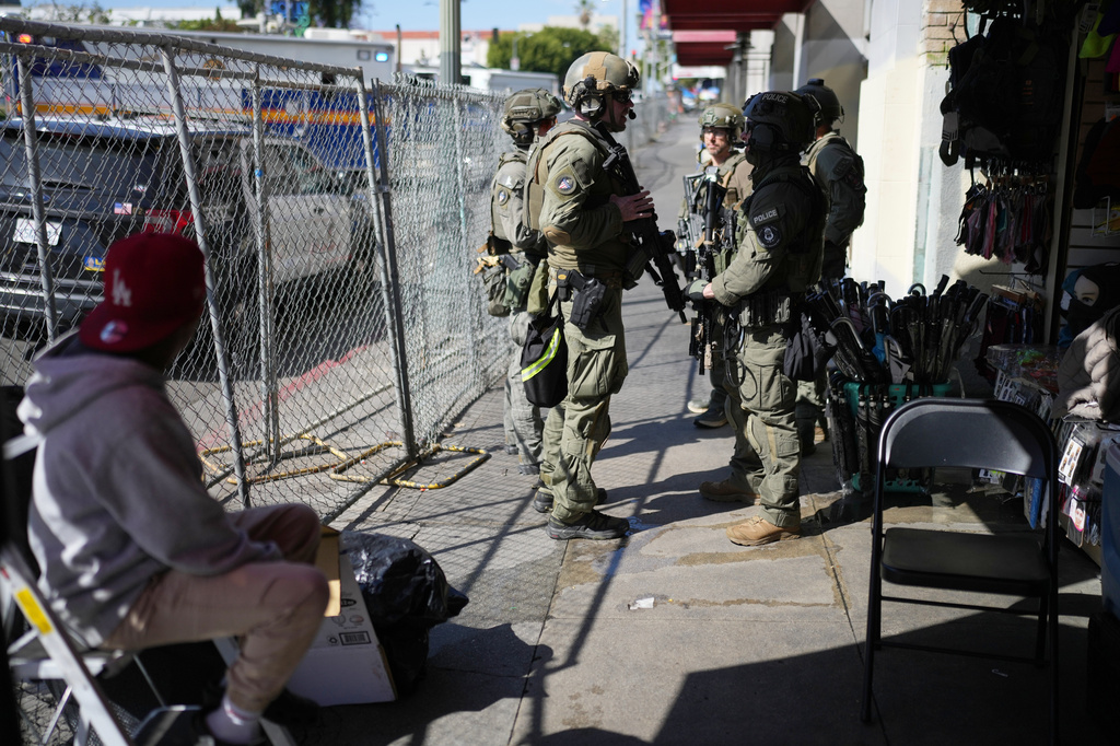 Law enforcement officers stand on a street near MacArthur Park after federal authorities made arrests on charges related to selling illicit drugs on Wednesday, May 6, 2026, in Los Angeles. (AP Photo/Jae C. Hong)