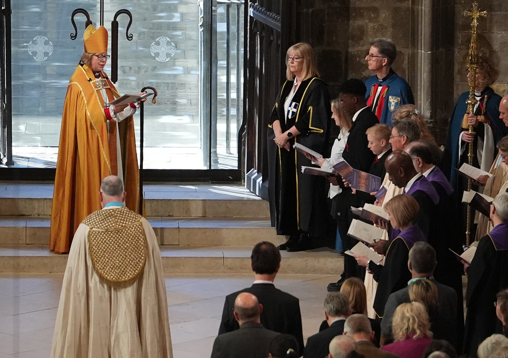 The Archbishop of Canterbury Dame Sarah Mullally is greeted by local school children Brooke, Macanthony and Solomon, from John Wallis Academy in Ashford, representing the cathedral gatekeepers, during the Enthronement Ceremony installing Dame Sarah Mullally as the 106th Archbishop of Canterbury, at Canterbury Cathedral, England, Wednesday March 25, 2026. (Gareth Fuller, Pool Photo via AP)
