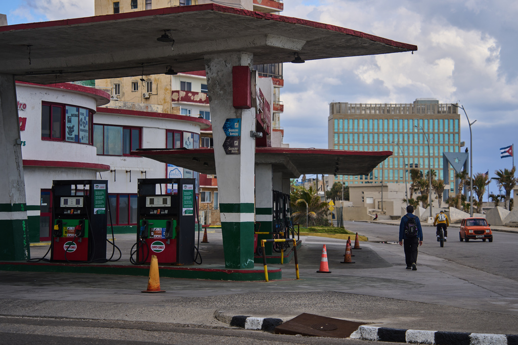 FILE - A man walks past a gas station that has run out of fuel, located near the U.S Embassy, pictured in the background, in Havana, Cuba, Feb. 7, 2026. (AP Photo/Ramon Espinosa, File)