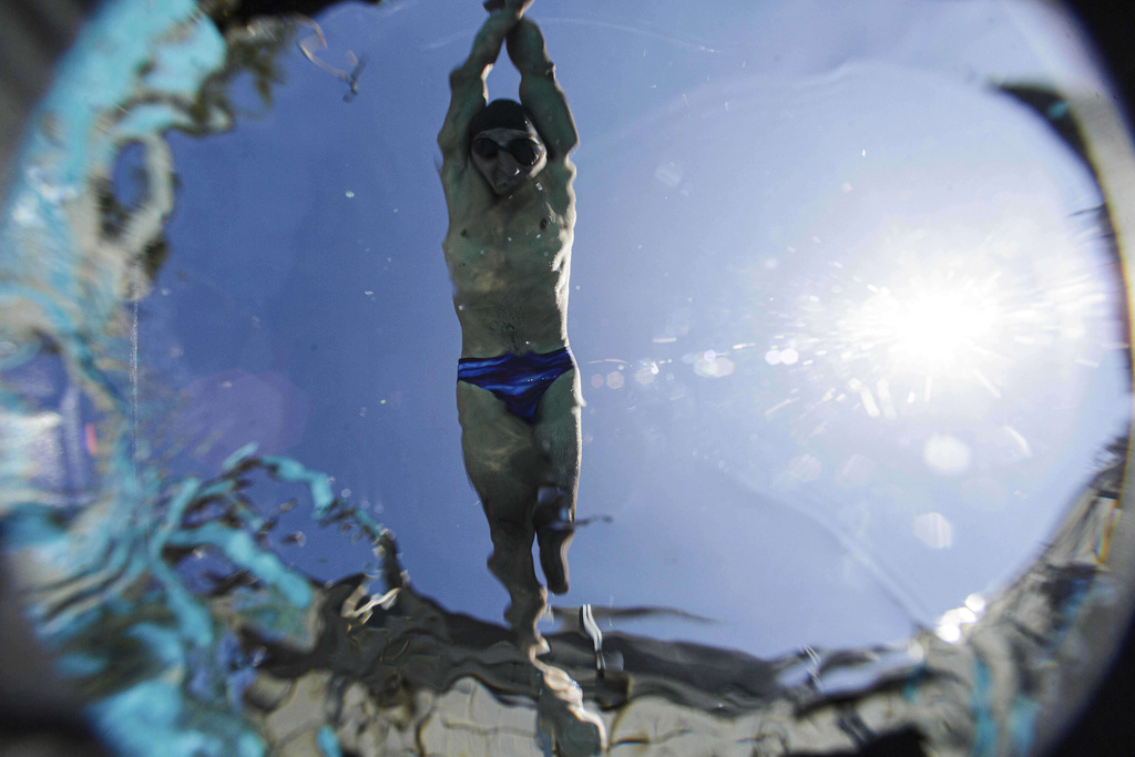 Ukrainian war veteran Pavlo Tovstyk jumps in a pool in Kyiv, Ukraine, Saturday, Aug. 16, 2025, during a training session to compete in a 6.5km swimming race across the Bosporus Strait. (AP Photo/Evgeniy Maloletka)
