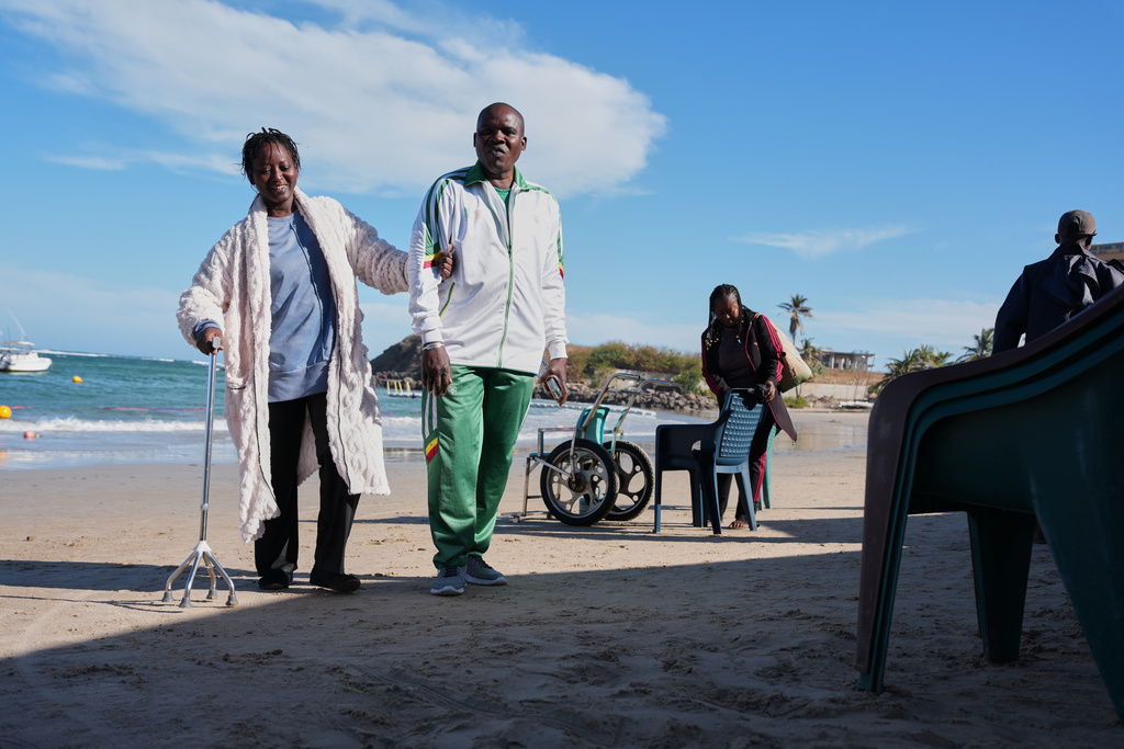 FILE - A woman walks with a relative after an aquatic therapy session in Dakar, Senegal, Saturday, Dec. 13, 2025. (AP Photo/Misper Apawu, File)