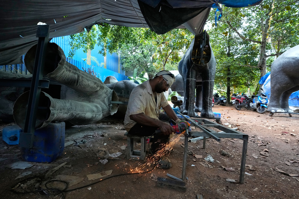 A worker welds parts to build a robotic elephant at a backyard workshop in Chalakudy, in the southern Indian state of Kerala, Friday, May 22, 2026. (AP Photo/Aijaz Rahi)