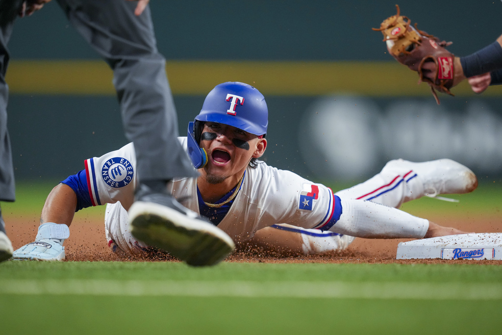 Texas Rangers' Alejandro Osuna reacts after being tagged out by Milwaukee Brewers third baseman Caleb Durbin while trying to move up on a single by Cody Freeman during the second inning of a baseball game Tuesday, Sept. 9, 2025, in Arlington, Texas. (AP Photo/Julio Cortez)