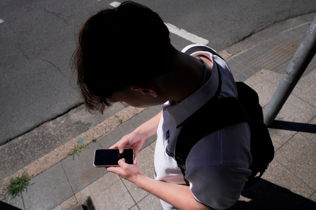FILE - A teenage boy uses his phone in Sydney, Nov. 8, 2024. (AP Photo/Rick Rycroft, File)