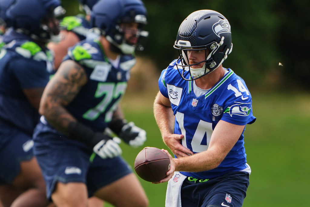 Seattle Seahawks quarterback Sam Darnold hands off the ball during the NFL football team's training camp, Saturday, July 25, 2026, in Renton, Wash. (AP Photo/Lindsey Wasson)