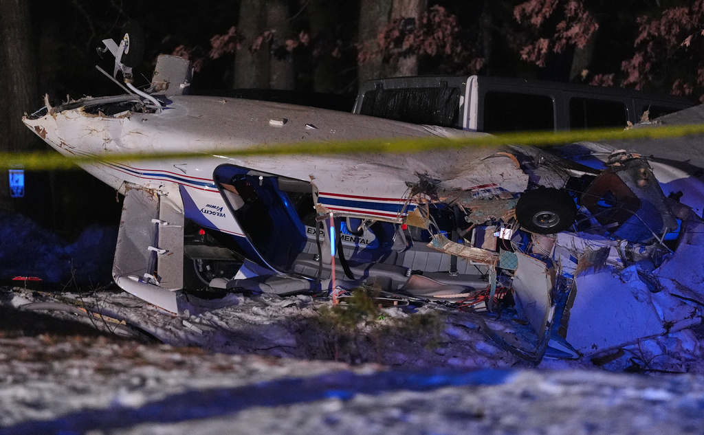 Airplane wreckage rests in a wooded neighborhood, Wednesday, Dec. 17, 2025, in Nashua, N.H. (AP Photo/Charles Krupa)