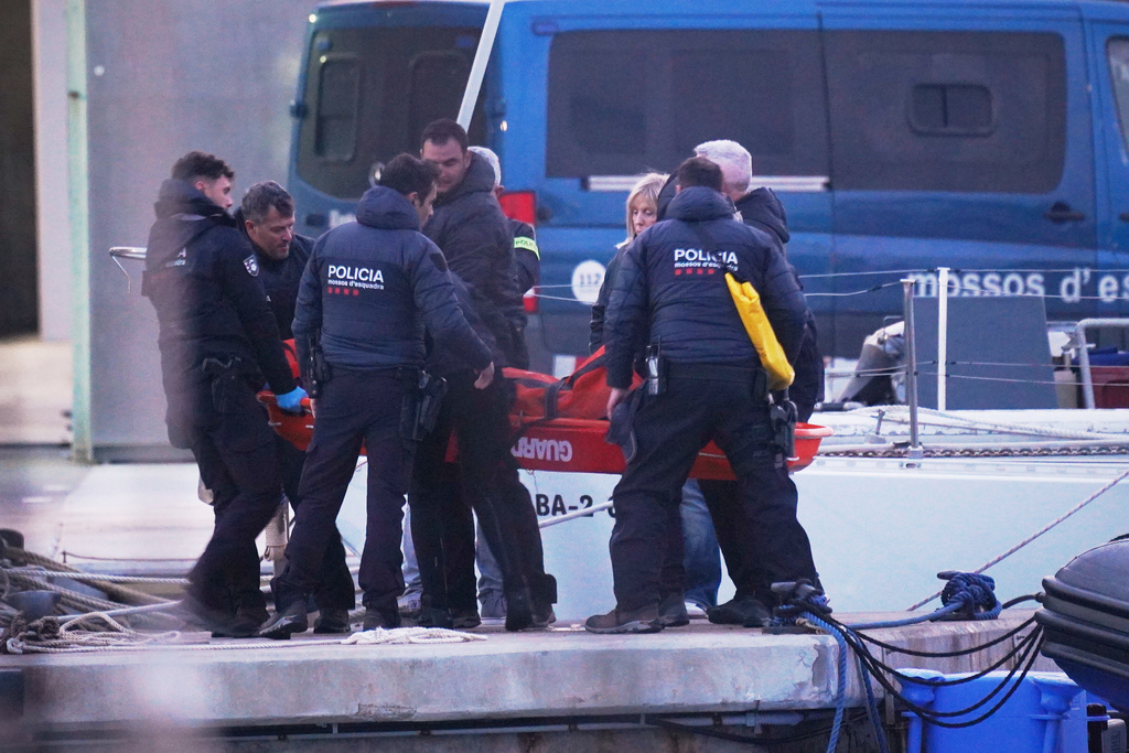 Police officers carry the body of a person found in the waters off the Port of Barcelona, Spain, Thursday, March 19, 2026. (AP Photo/Alfonso Beato)