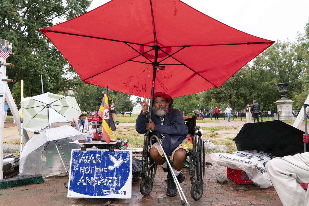 Philipos Melaku-Bello flashes the V sign during Peace Vigil in Lafayette Park across from the White House in Washington, Sunday, Sept. 7, 2025. (AP Photo/Jose Luis Magana)