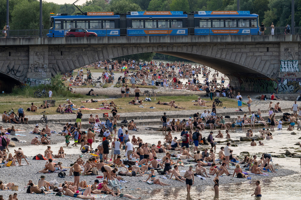 Swimmers enjoy cooling off in the waters of the Isar and on the gravel banks around the Reichenbach Bridge in Munich, Germany, Sunday, June 28, 2026. (Peter Kneffel/dpa via AP)