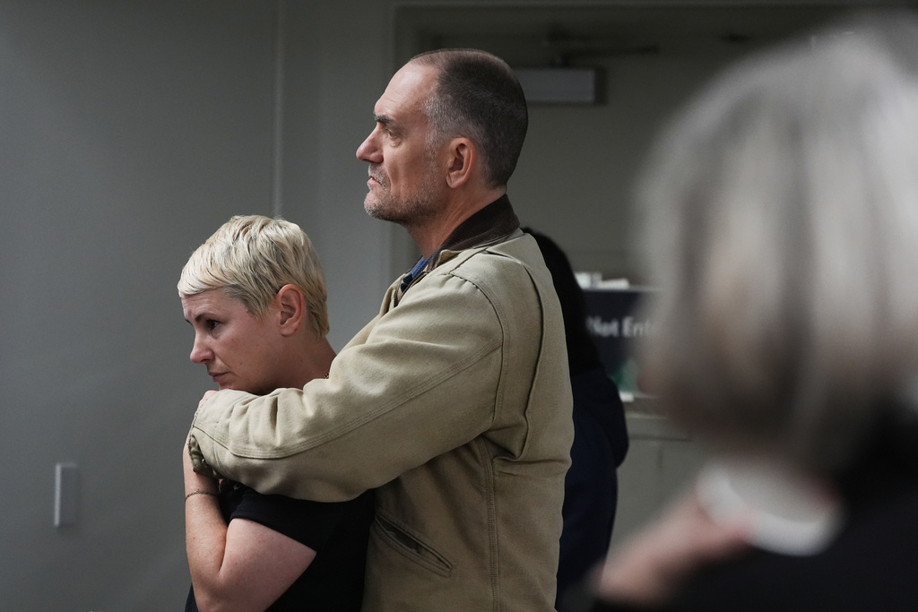 Eleanor Godfrey, left, is hugged by her husband Seth Morris during a gathering of survivors on the one-year anniversary of the Eaton Fire Wednesday, Jan. 7, 2026, in Altadena, Calif. (AP Photo/Gregory Bull)