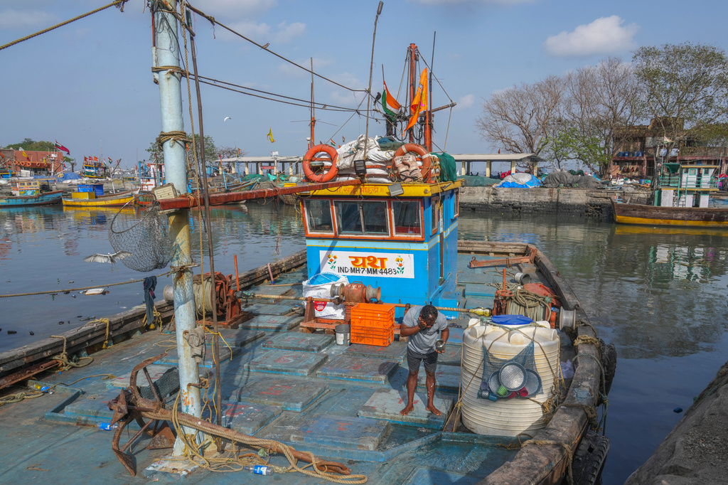 A fisherman washes his face on the deck of a boat anchored at Sassoon Dock in Mumbai, India, Tuesday, April 7, 2026. (AP Photo/Rafiq Maqbool)