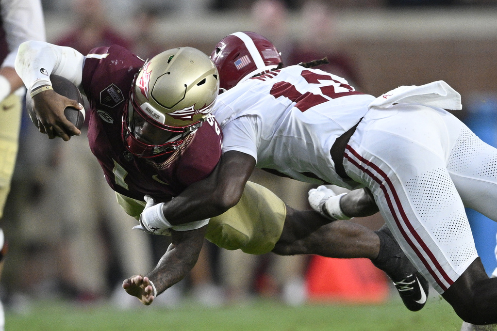 Florida State quarterback Tommy Castellanos (1) dives for extra yardage as Alabama defensive back Zavier Mincey (12) makes the tackle during the second half of an NCAA college football game, Saturday, Aug. 30, 2025, in Tallahassee, Fla. (AP Photo/Phelan M. Ebenhack)