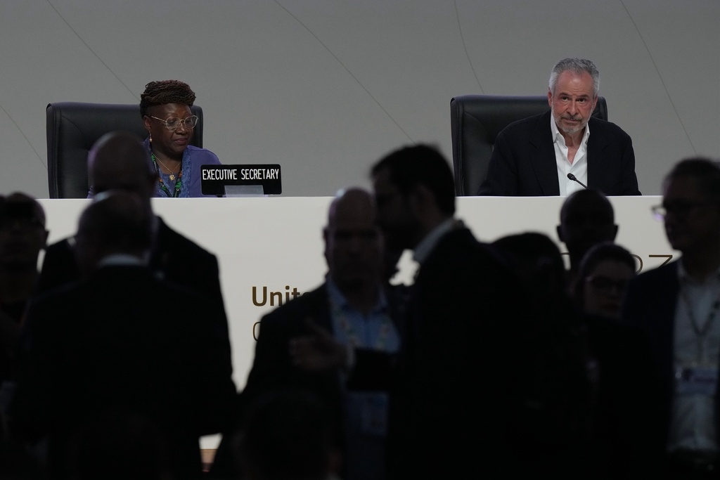 People come and go from a plenary session as André Corrêa do Lago, COP30 president, sits at back right, during the COP30 U.N. Climate Summit, Monday, Nov. 17, 2025, in Belem, Brazil. (AP Photo/Fernando Llano)